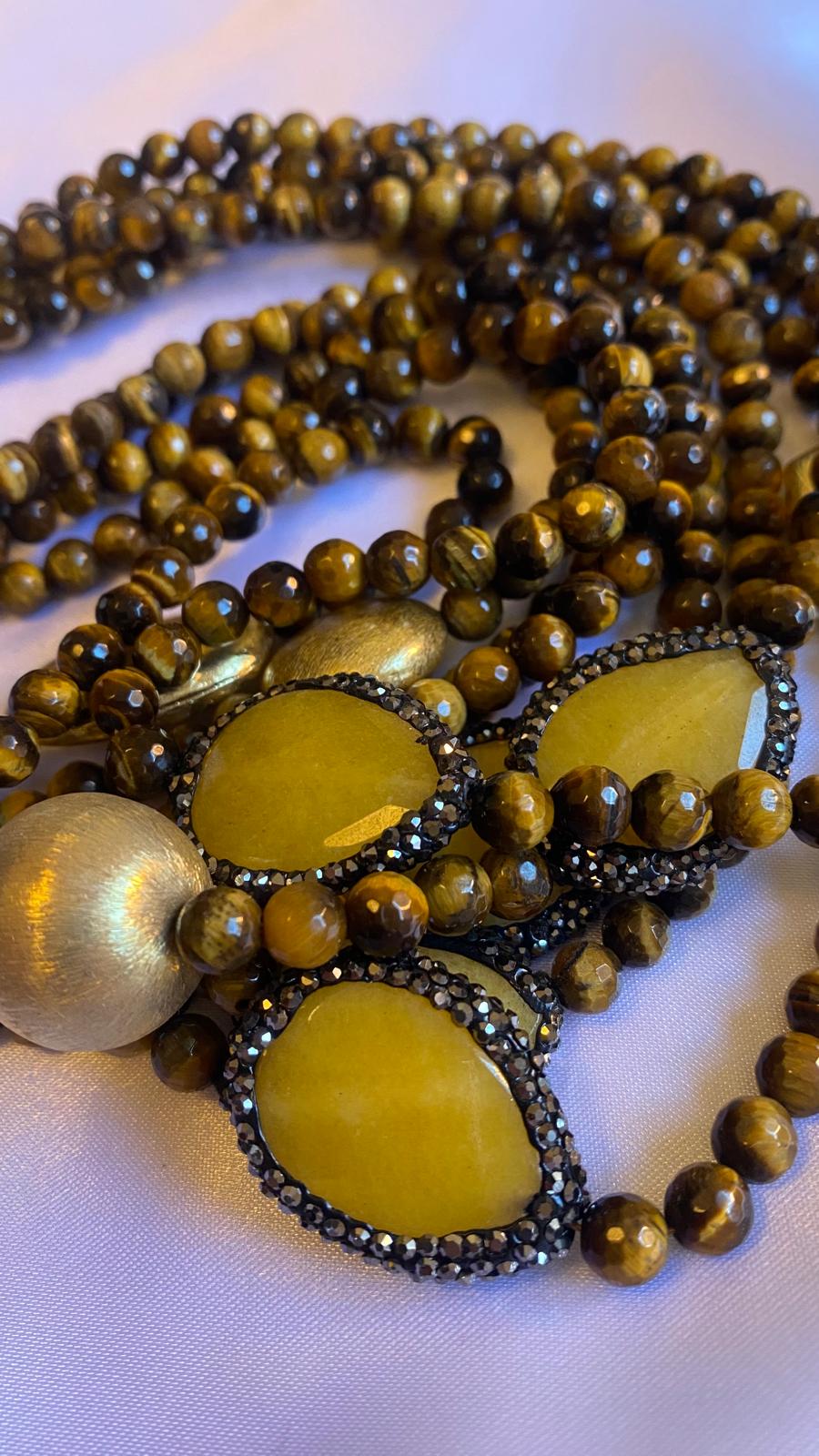 Multi-strand Necklace made of Tiger's eye, Golden nuggets, and Glitter with a Mother of Pearl clasp.